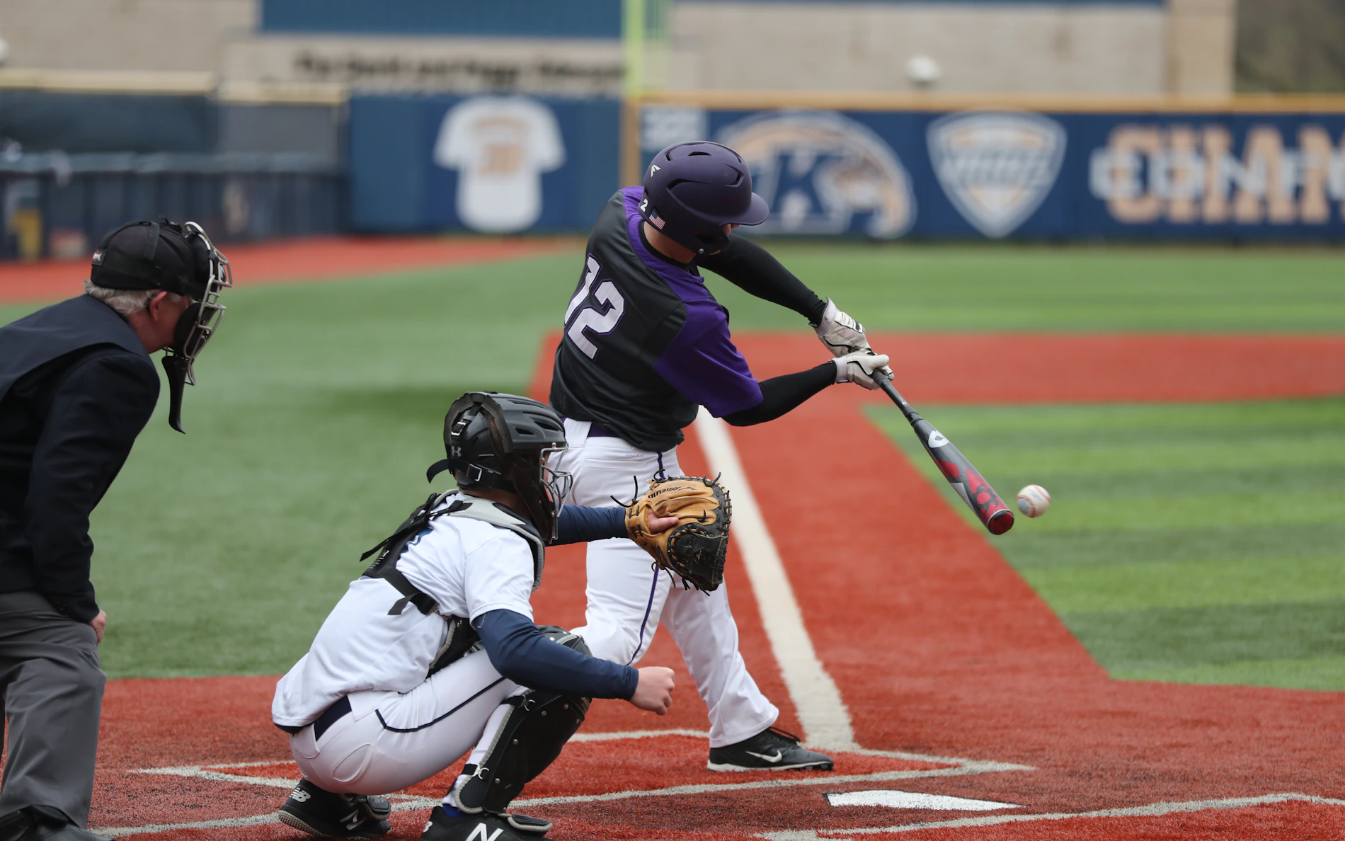 Baseball player completing a swing during a game